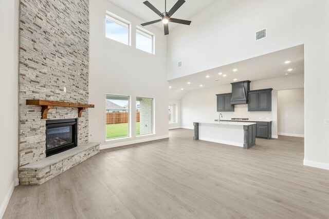1233 Sylvia St, Desoto, TX 75115 - unfurnished living room featuring ceiling fan, a sink, light wood-style flooring, baseboards, and a high ceiling