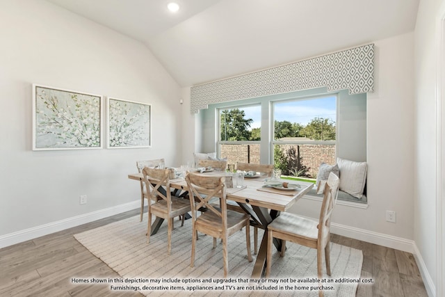 dining area featuring lofted ceiling and light hardwood / wood-style flooring