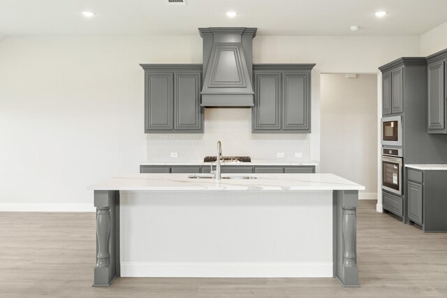1233 Sylvia St, Desoto, TX 75115 - kitchen featuring stainless steel oven, gray cabinets, white microwave, tasteful backsplash, and custom exhaust hood