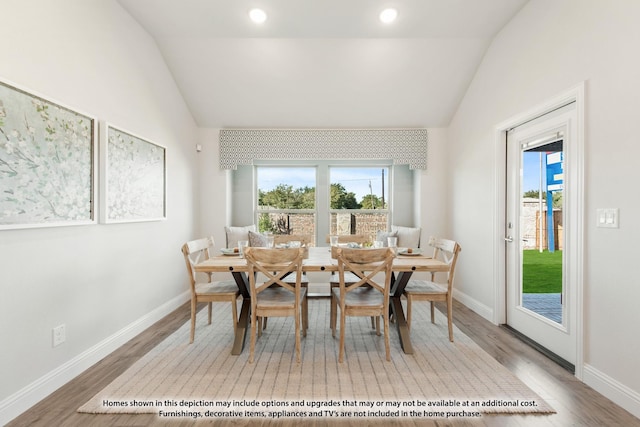 dining room with hardwood / wood-style floors and vaulted ceiling