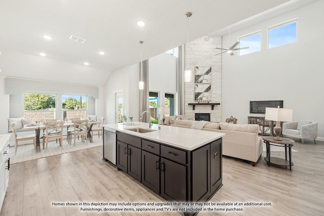 kitchen featuring dishwasher, an island with sink, sink, ceiling fan, and light hardwood / wood-style flooring