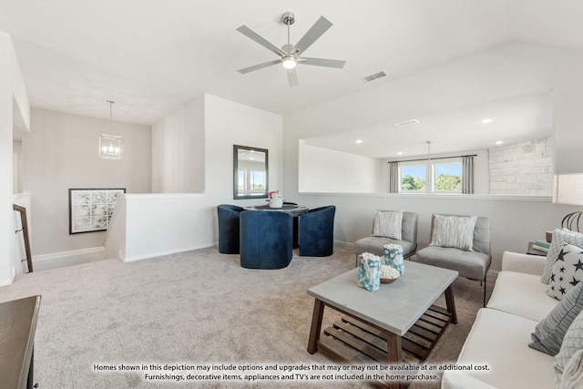 living room featuring ceiling fan with notable chandelier and light colored carpet