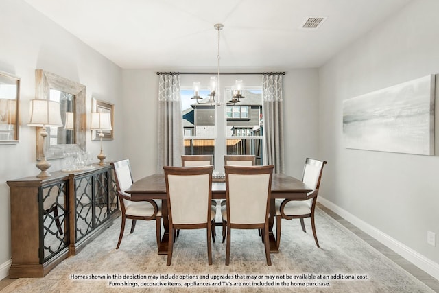 dining room with light hardwood / wood-style flooring and an inviting chandelier