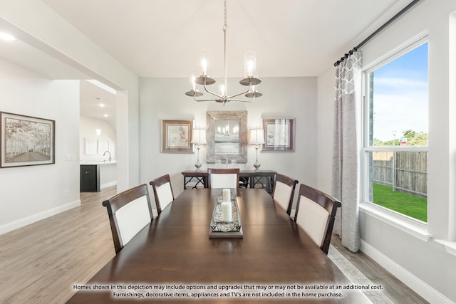 dining space with a chandelier, light hardwood / wood-style floors, and sink