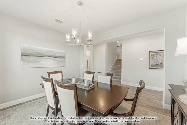 dining room with an inviting chandelier and light hardwood / wood-style flooring