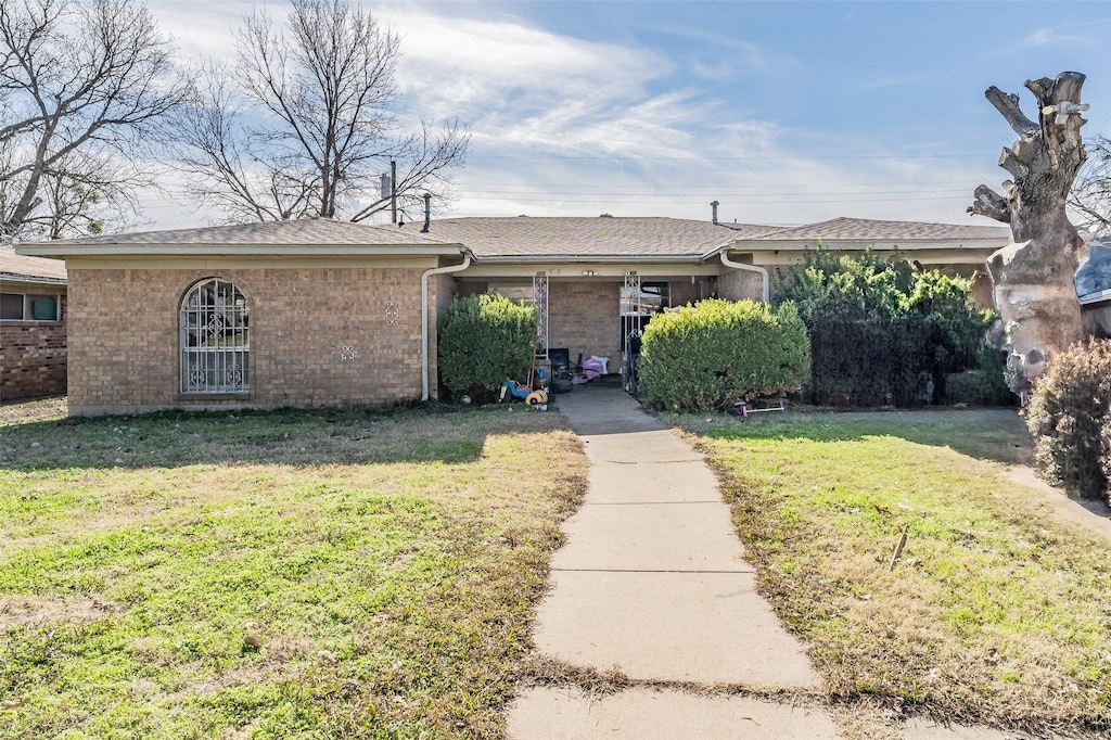 ranch-style home featuring a front lawn