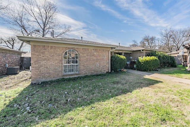 exterior space featuring central AC unit and a yard