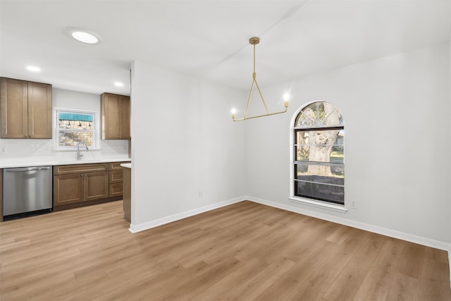 unfurnished dining area with light hardwood / wood-style floors, plenty of natural light, and a chandelier