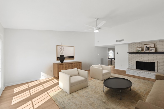 living room featuring visible vents, lofted ceiling, ceiling fan, and wood finished floors