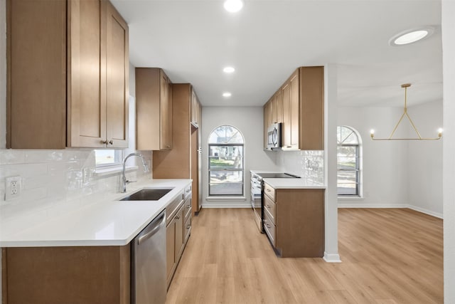 kitchen with pendant lighting, decorative backsplash, light wood-type flooring, appliances with stainless steel finishes, and a chandelier