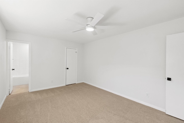 unfurnished bedroom featuring baseboards, light carpet, a ceiling fan, and ensuite bathroom