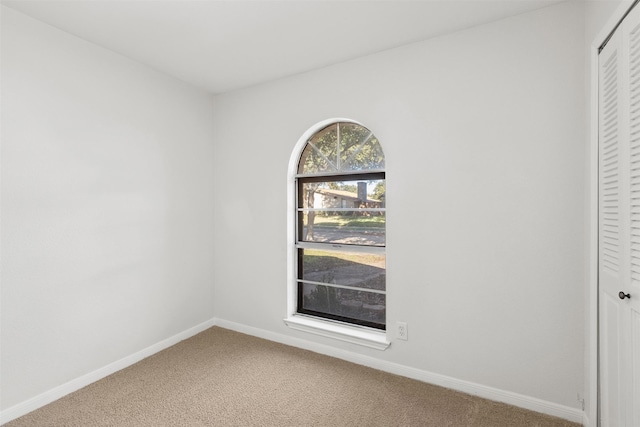 carpeted spare room with baseboards