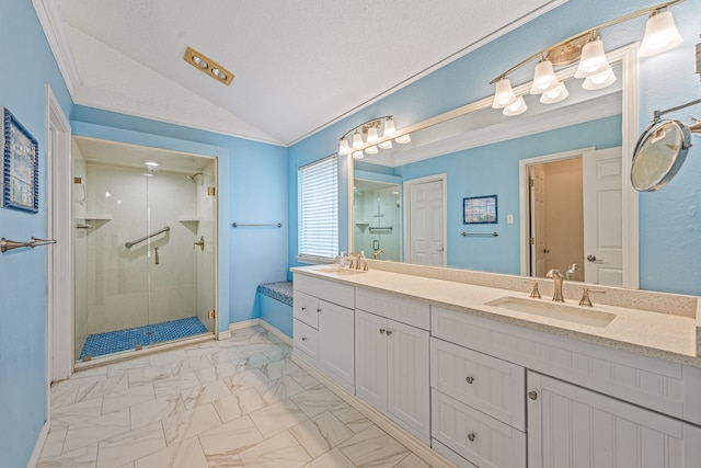 bathroom with a textured ceiling, lofted ceiling, a shower with shower door, and vanity