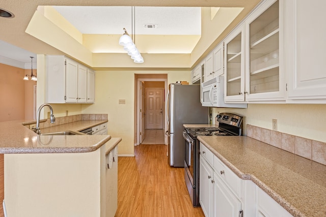 kitchen with stainless steel appliances, sink, kitchen peninsula, and decorative light fixtures