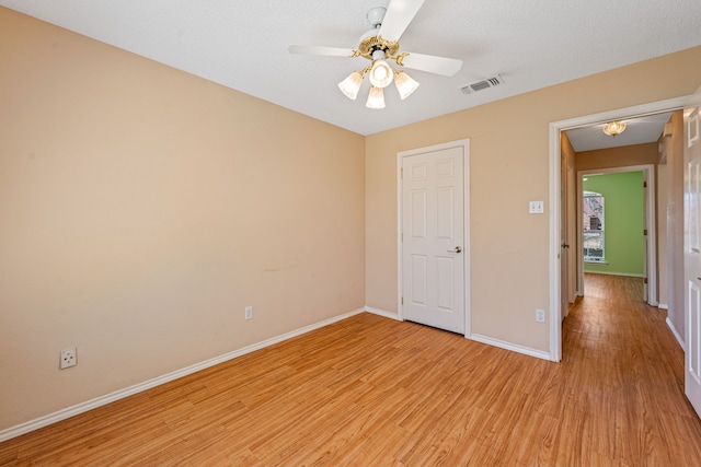 unfurnished bedroom with light wood-type flooring, ceiling fan, and a textured ceiling