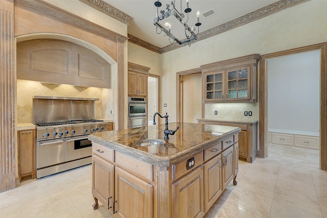 kitchen featuring pendant lighting, sink, appliances with stainless steel finishes, a center island with sink, and decorative backsplash