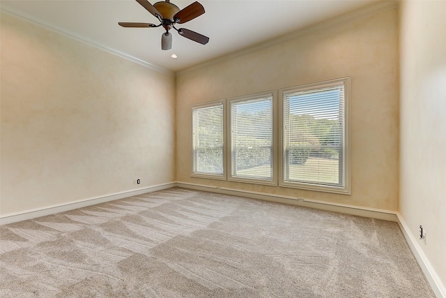 empty room with crown molding, light colored carpet, and ceiling fan