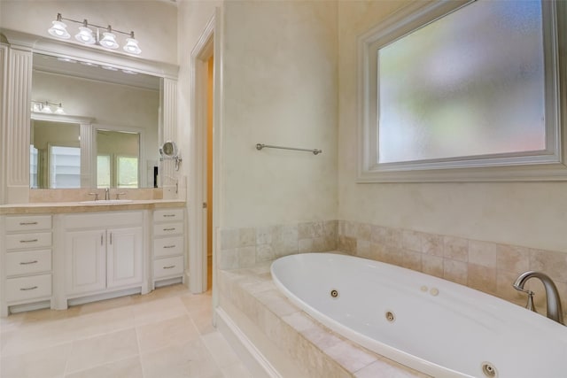 bathroom with a relaxing tiled tub, tile patterned floors, and vanity