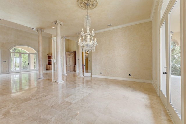 unfurnished room with french doors, an inviting chandelier, crown molding, a towering ceiling, and decorative columns