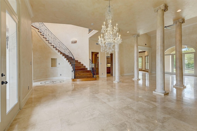 foyer featuring a notable chandelier, a high ceiling, and ornate columns