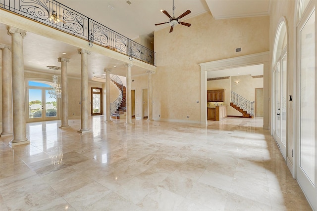 spare room featuring ceiling fan, a towering ceiling, ornamental molding, and ornate columns