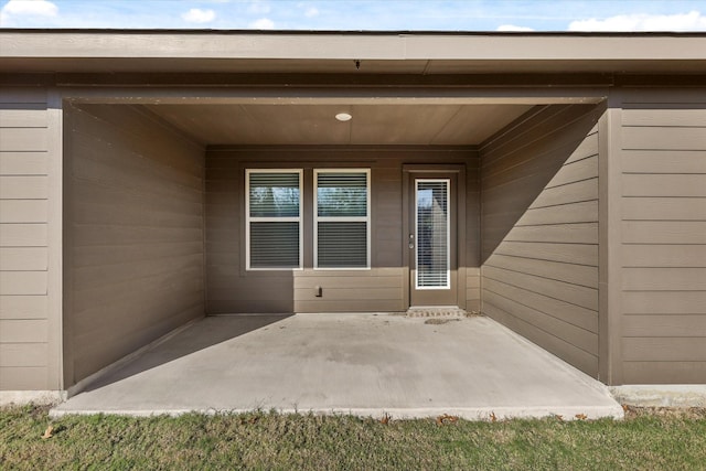 view of exterior entry with a patio