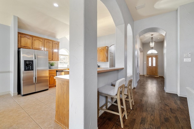 kitchen with light tile patterned flooring, stainless steel appliances, and a breakfast bar