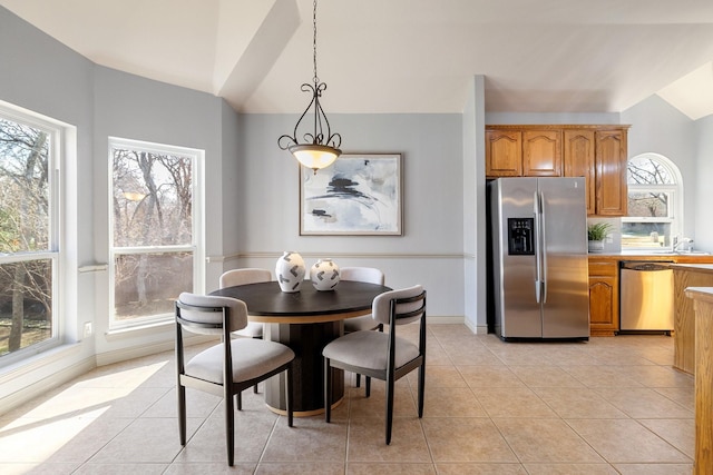 tiled dining space featuring lofted ceiling