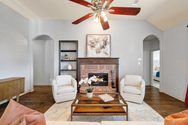 living room with ceiling fan, lofted ceiling, a fireplace, dark hardwood / wood-style floors, and built in features