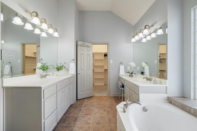 bathroom featuring a tub to relax in, vanity, and vaulted ceiling