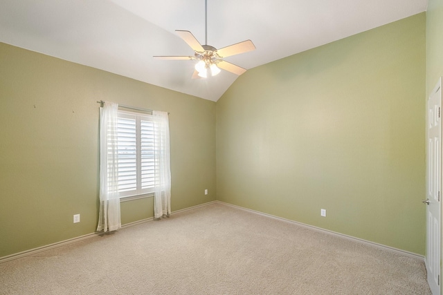 empty room featuring ceiling fan, light colored carpet, and vaulted ceiling