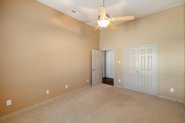 unfurnished bedroom featuring ceiling fan, light carpet, and high vaulted ceiling