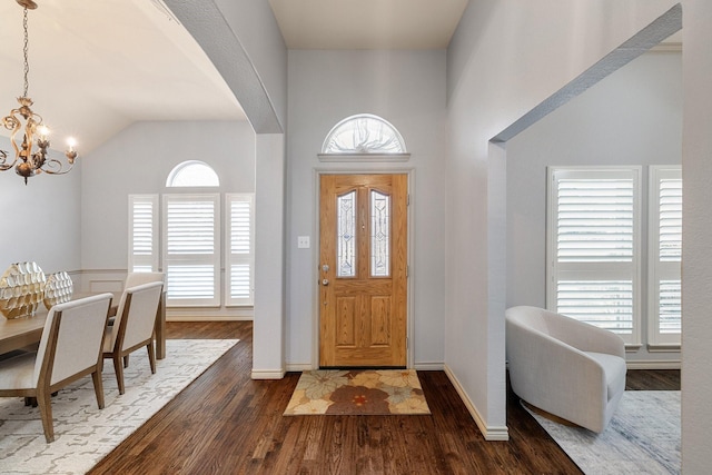 entrance foyer featuring a high ceiling, dark wood-type flooring, and a notable chandelier