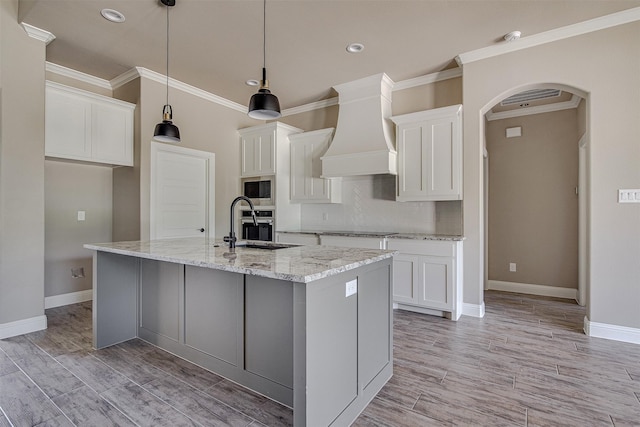 kitchen featuring white cabinets, premium range hood, and stainless steel appliances