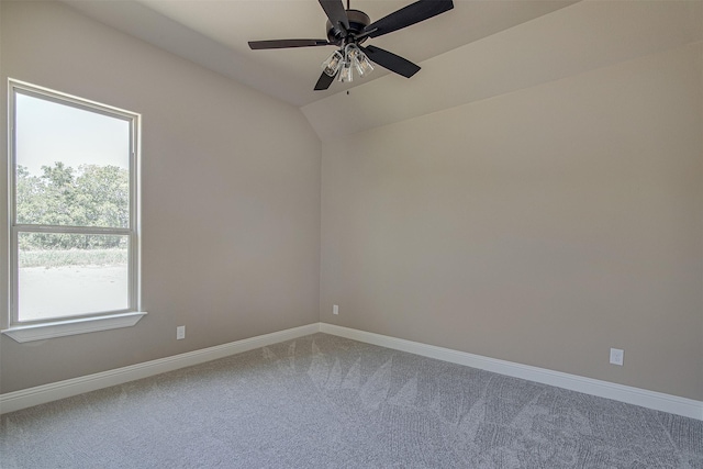 spare room featuring lofted ceiling, ceiling fan, a wealth of natural light, and carpet flooring