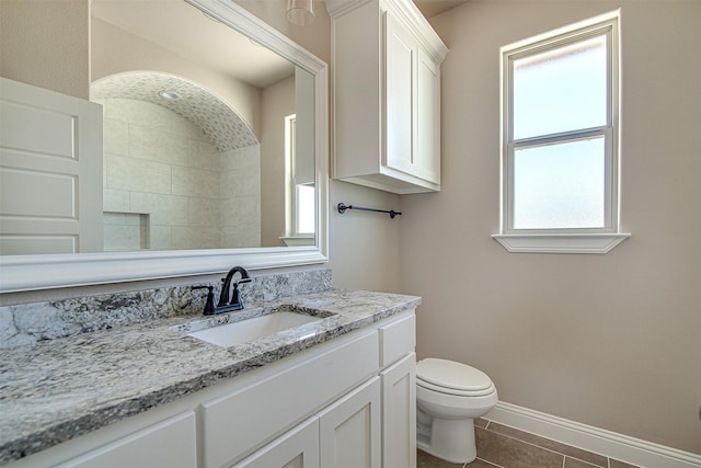 bathroom with toilet, vanity, and tile patterned flooring