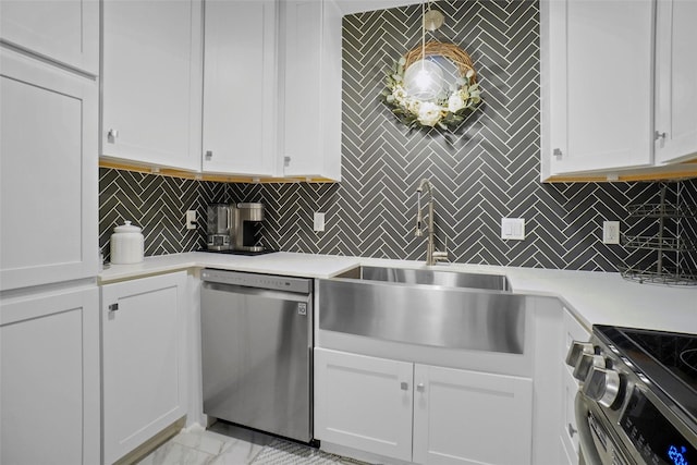 kitchen with tasteful backsplash, white cabinets, appliances with stainless steel finishes, and sink