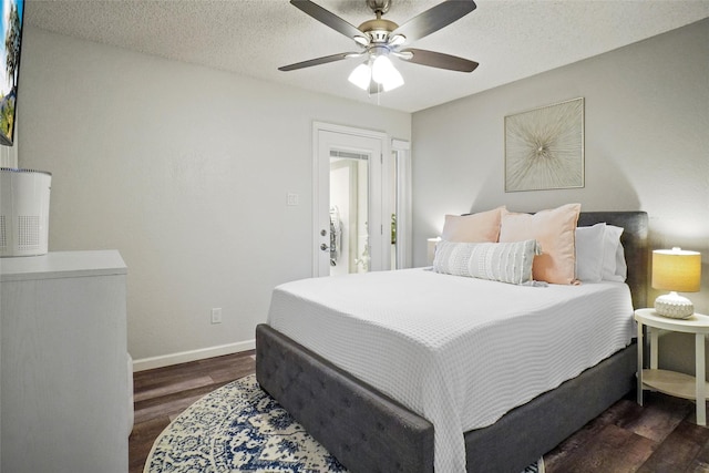 bedroom with ceiling fan, dark wood-type flooring, and a textured ceiling