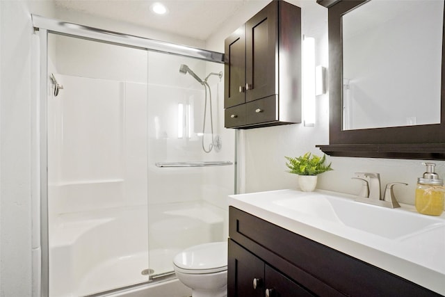 bathroom with toilet, an enclosed shower, and vanity