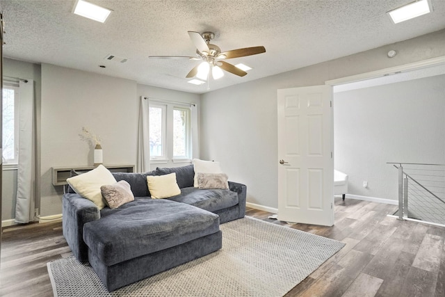 living room with ceiling fan, hardwood / wood-style floors, and a textured ceiling