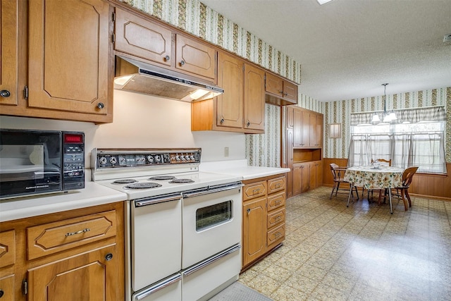 kitchen featuring decorative light fixtures, double oven range, a textured ceiling, and a notable chandelier