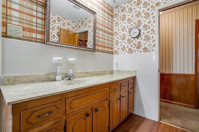 bathroom with hardwood / wood-style flooring, a textured ceiling, and vanity