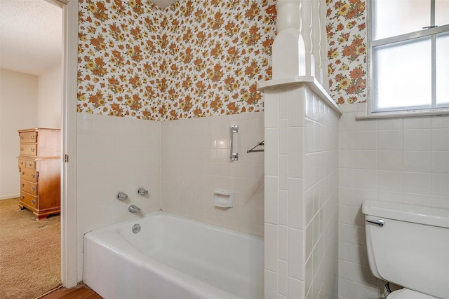 bathroom featuring toilet, tile walls, and a bathing tub