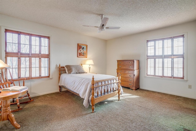 carpeted bedroom featuring ceiling fan and a textured ceiling