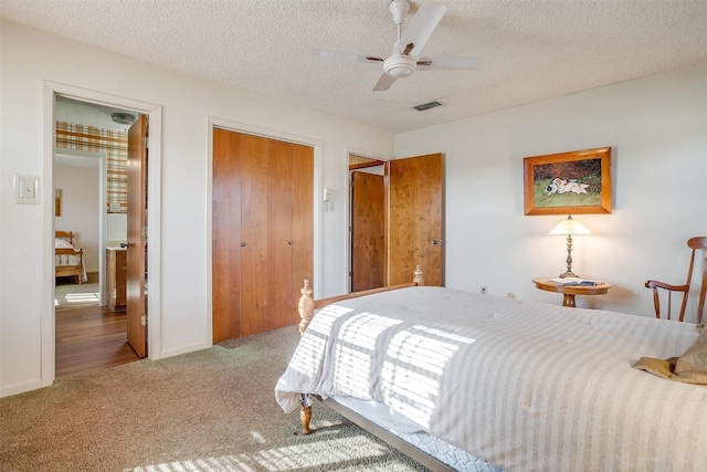 carpeted bedroom featuring a textured ceiling, ceiling fan, and a closet