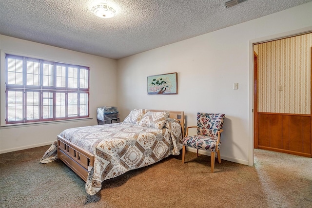 bedroom featuring a textured ceiling, carpet flooring, and wood walls