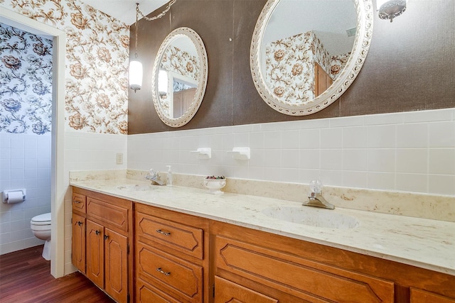 bathroom with toilet, tile walls, wood-type flooring, and vanity