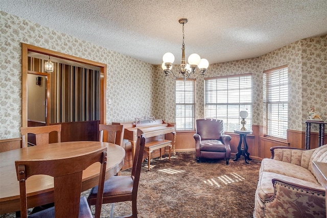 carpeted dining space with a textured ceiling and an inviting chandelier