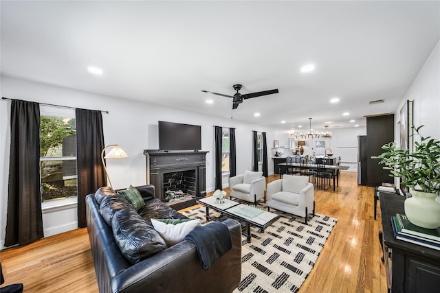 living room with ceiling fan and light wood-type flooring