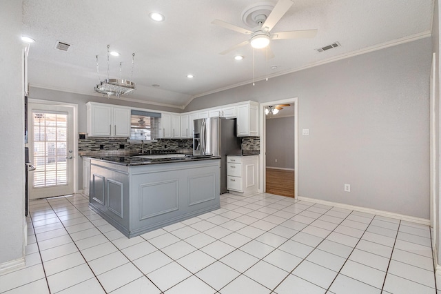 kitchen featuring vaulted ceiling, crown molding, white cabinetry, and a kitchen island